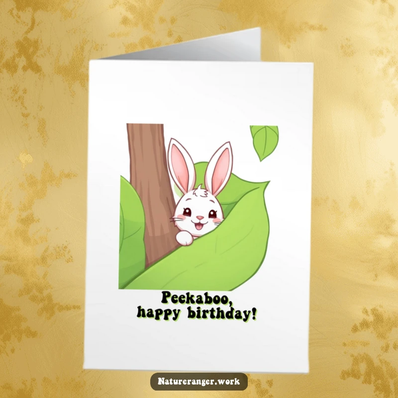 Free Printable Birthday Card: Playful cartoon rabbit peeking from behind a large forest leaf, shy, cute, downloadable.